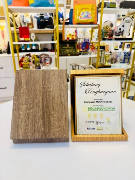 Kotak plak Version 2 coklat cerah dalam keadaan terbuka, dengan contoh plak penghargaan